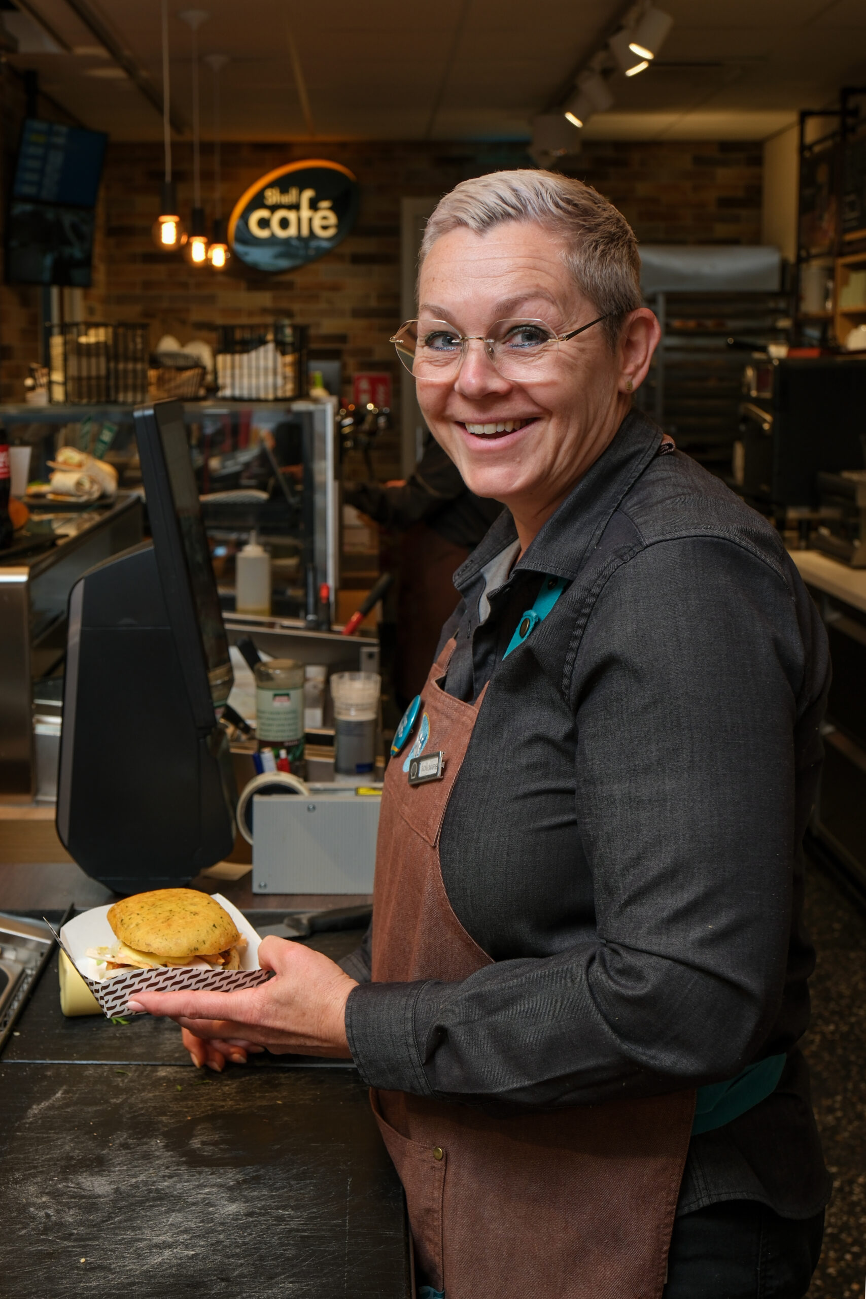 2025-05-15 Shell test-4 Bakkerij medewerker die een broodje aan het maken is bij Shell Café Kloosters